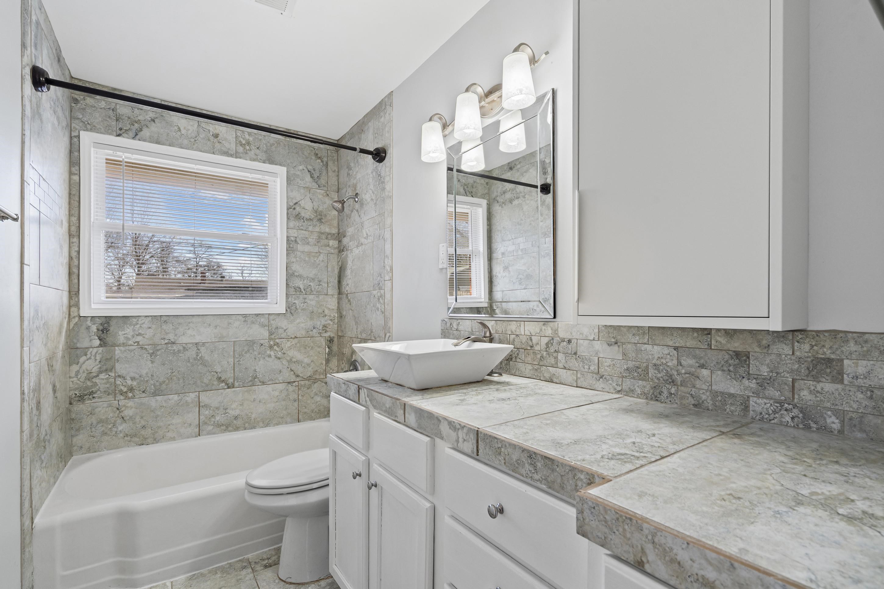 506 McDermitt Road Memphis, TN 38120 - Photo 18 of 29 Bathroom with vanity, shower / washtub combination, and backsplash