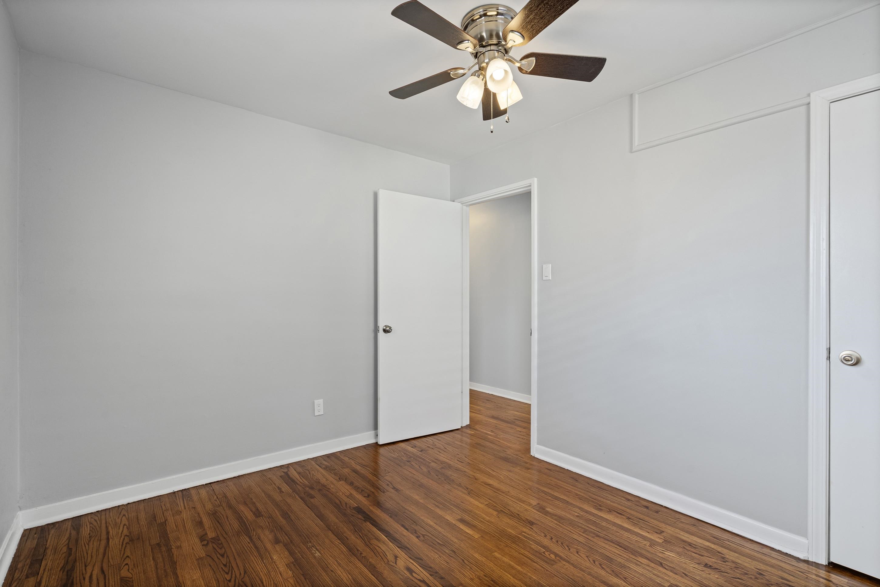 506 McDermitt Road Memphis, TN 38120 - Photo 20 of 29 Unfurnished bedroom featuring dark wood-style flooring and a ceiling fan
