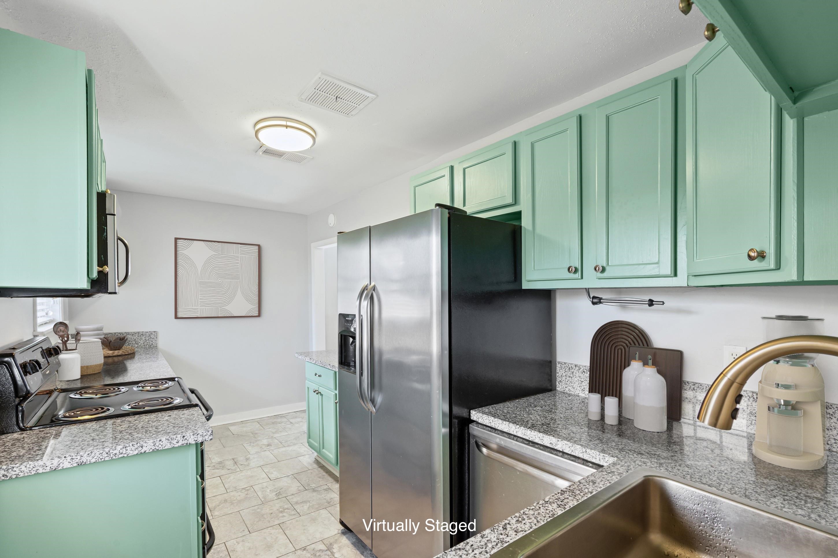 506 McDermitt Road Memphis, TN 38120 - Photo 7 of 29 Kitchen with green cabinetry, stainless steel appliances, and light stone counters