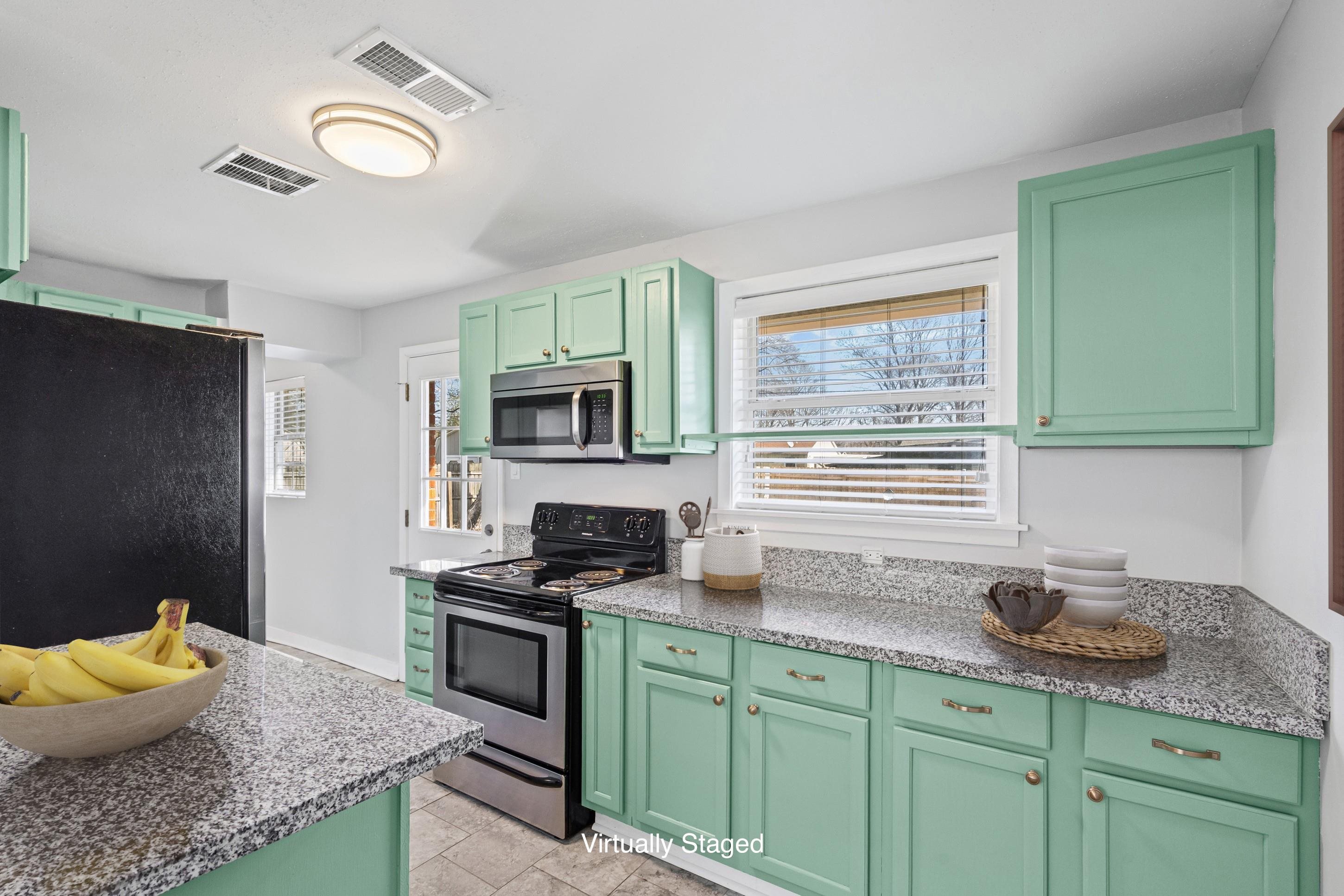 506 McDermitt Road Memphis, TN 38120 - Photo 9 of 29 Kitchen featuring green cabinets, stainless steel appliances, and light stone counters