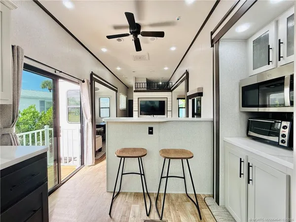 a living room with furniture a flat screen tv and a floor to ceiling window