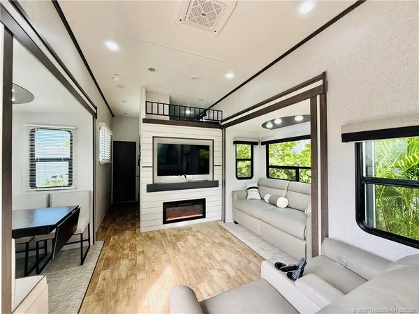 a living room with furniture a flat screen tv and a fireplace