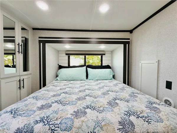 a bedroom with a bed and a large window