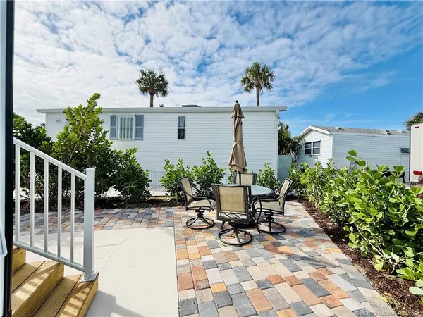 a front view of a house with a yard and potted plants