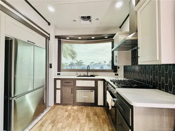 a open kitchen with stainless steel appliances granite countertop a stove and a sink