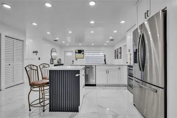 a kitchen with refrigerator cabinets and a sink