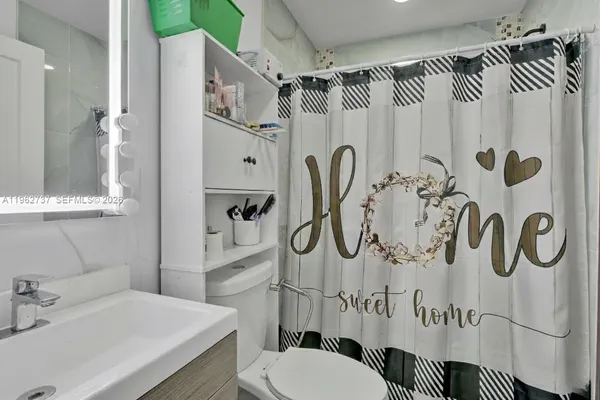 a bathroom with a sink toilet and shower