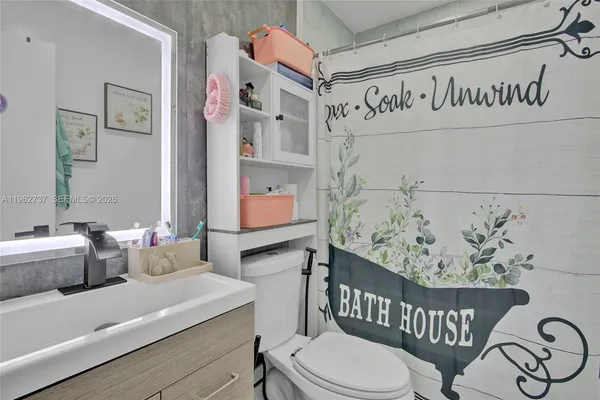 a bathroom with a sink mirror vanity and toilet