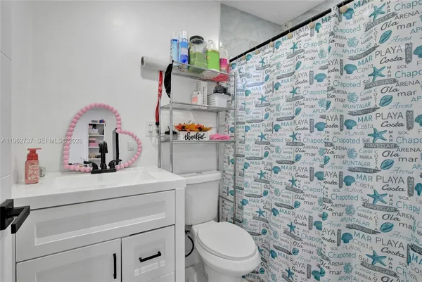 a bathroom with a sink toilet vanity and shower