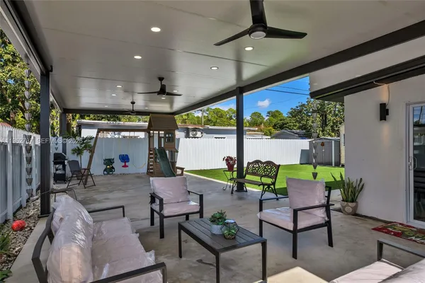 a view of a patio with table and chairs under an umbrella