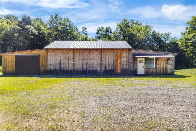 a front view of a house with a yard and a large tree