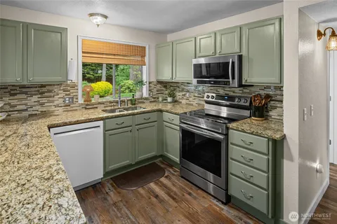 a kitchen with stainless steel appliances a stove sink and microwave