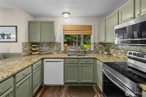 a kitchen with stainless steel appliances granite countertop a sink stove and microwave