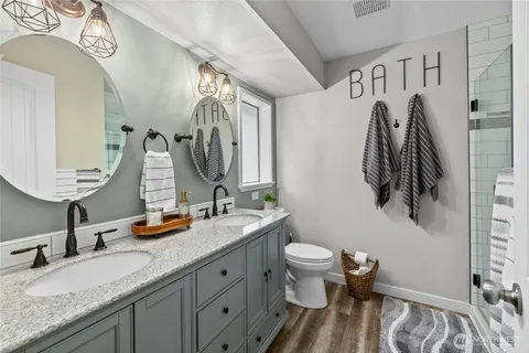 a bathroom with a granite countertop sink a toilet and a mirror