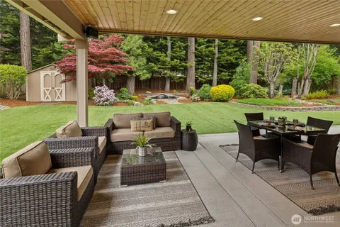 a view of a patio with table and chairs potted plants and large tree
