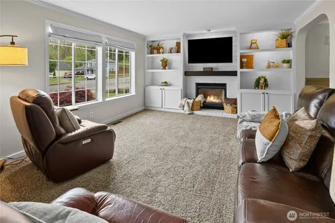 a living room with furniture a flat screen tv and a fireplace