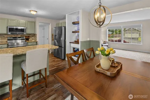 a living room with furniture kitchen view and a wooden floor