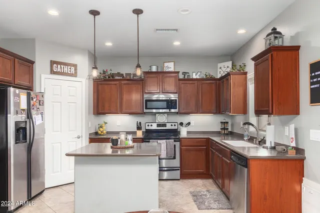 a kitchen with stainless steel appliances granite countertop a sink a stove and a refrigerator