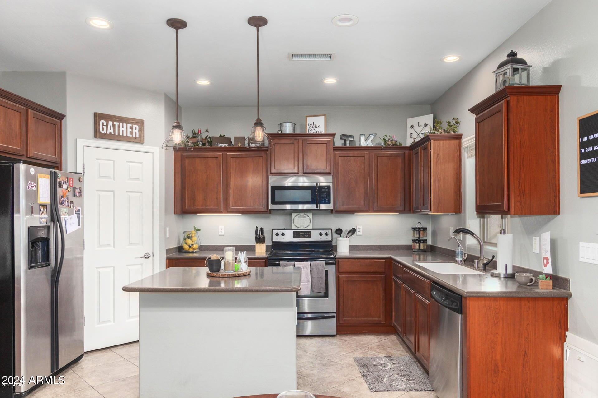 2217 West Kathleen Road Phoenix, AZ 85023 - Photo 11 of 42 a kitchen with stainless steel appliances granite countertop a sink a stove and a refrigerator
