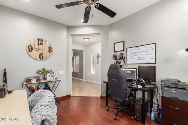 a view of a workspace with furniture and a ceiling fan