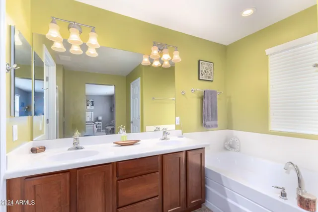 a bathroom with a sink a large mirror and a bathtub with shower