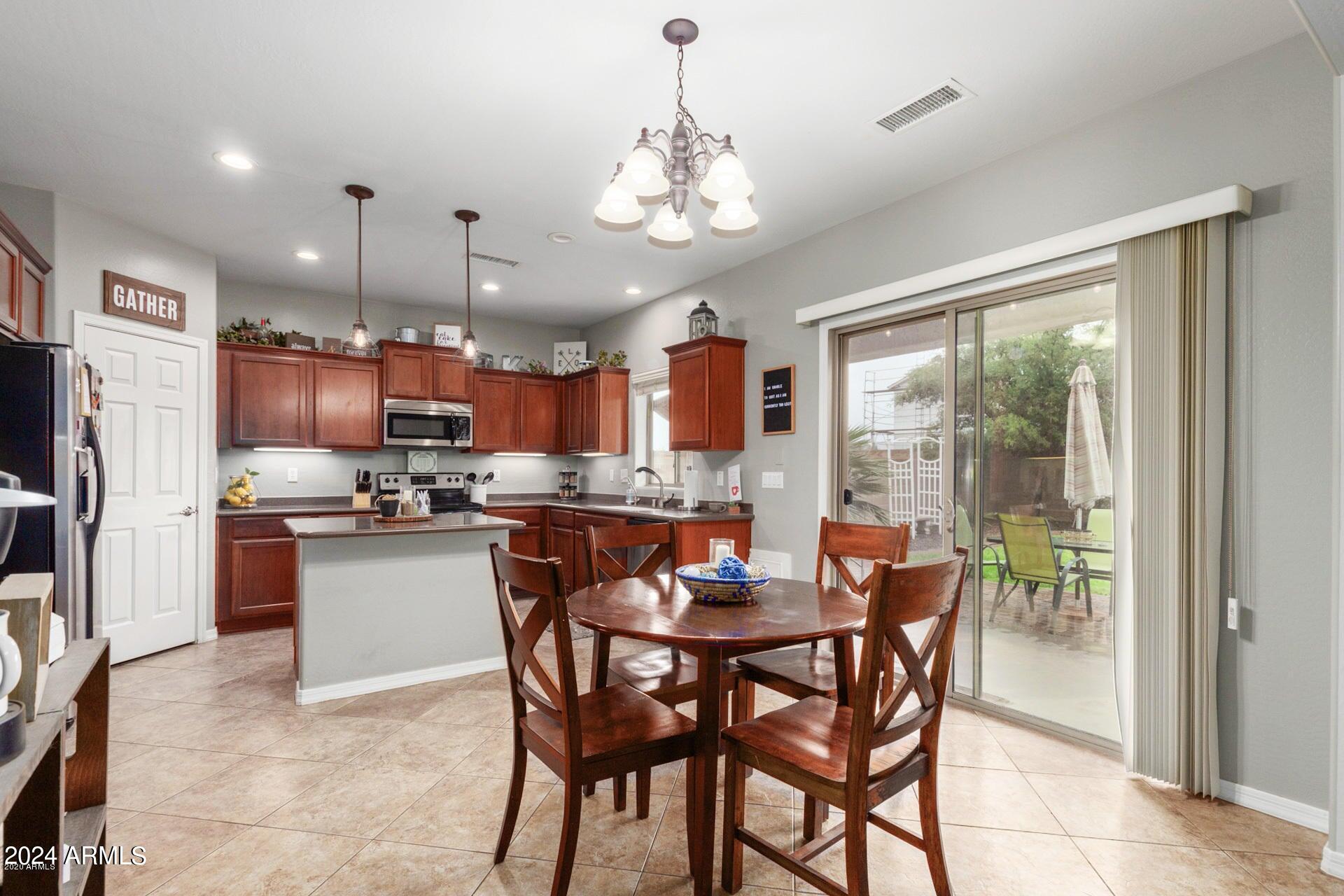 2217 West Kathleen Road Phoenix, AZ 85023 - Photo 8 of 42 a view of a dining room with furniture large window and stainless steel appliances