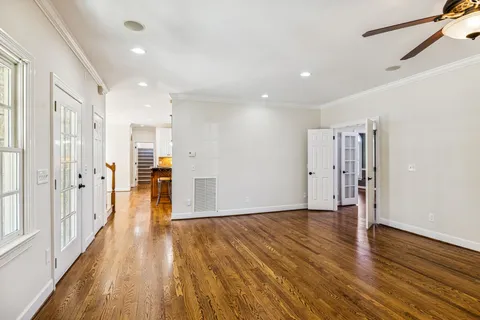 a kitchen with stainless steel appliances granite countertop a sink a stove and a refrigerator with wooden floors