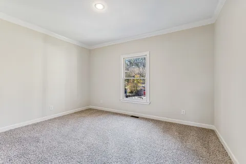 a view of a room with wooden floors and kitchen view