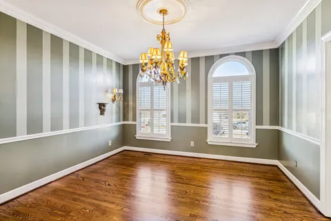 a view of a livingroom with a fireplace a ceiling fan and windows
