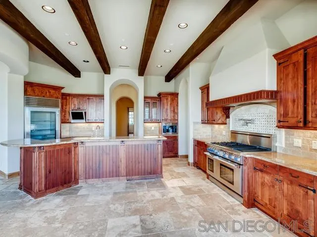 18287 Via Ambiente Rancho Santa Fe, CA 92067 - Photo 9 of 24 a large kitchen with stainless steel appliances granite countertop a stove a sink dishwasher and wooden cabinets with wooden floor