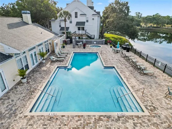 a view of a house with pool and chairs