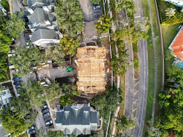 an aerial view of residential houses with outdoor space and trees