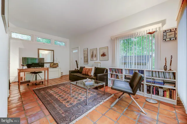 a living room with furniture a rug and a table