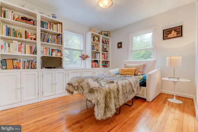 a bed sitting in a bedroom next to a book shelf
