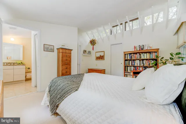 a bedroom with a bed and a large mirror