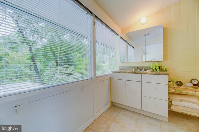 a bathroom with a granite countertop sink and a window