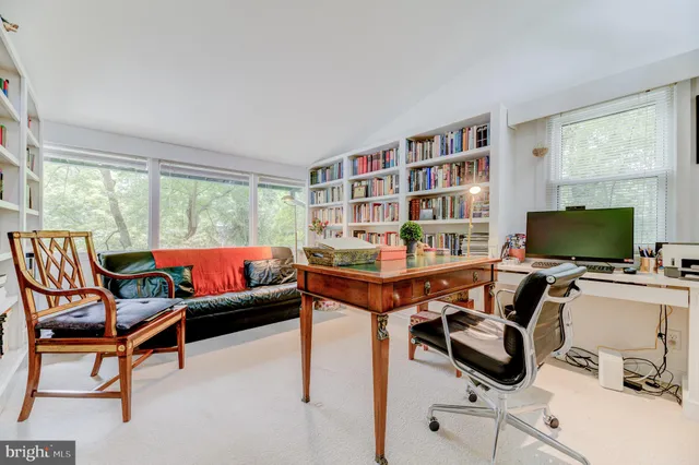 a view of a livingroom with workspace and a window