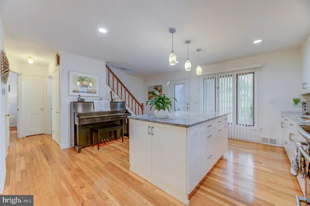 a open kitchen with stainless steel appliances granite countertop a stove and a wooden floors