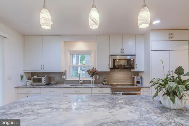 a kitchen with sink a microwave and cabinets