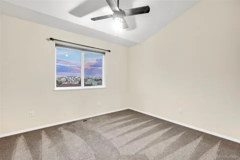 an empty room with a window and a ceiling fan