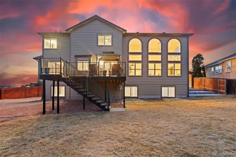 a view of a house with large windows and a yard