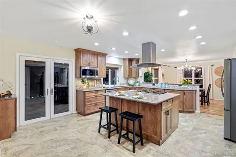 a kitchen with kitchen island a large counter top space and stainless steel appliances