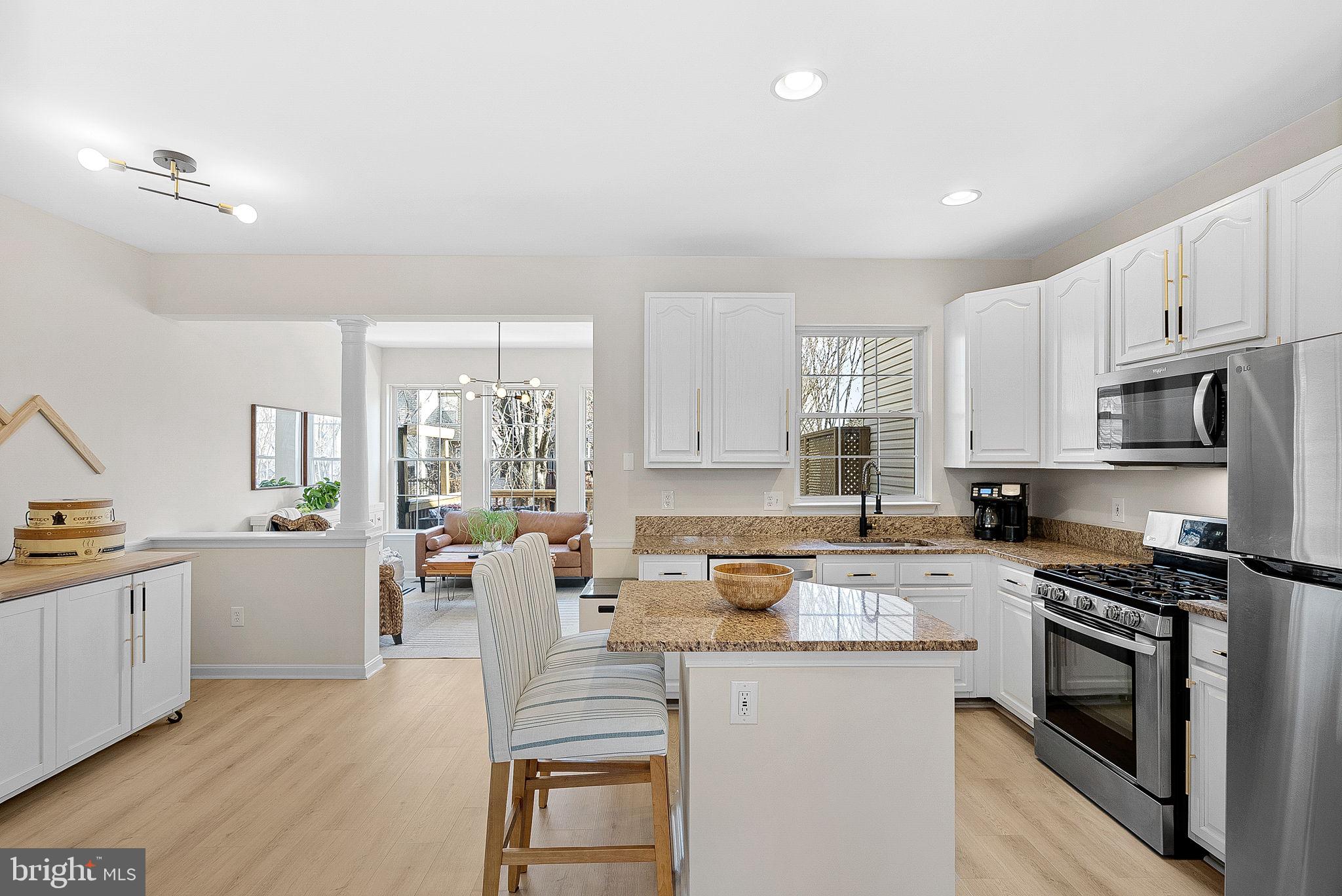 20392 Farmgate Terrace Ashburn, VA 20147 - Photo 18 of 62 a kitchen with stainless steel appliances granite countertop a stove top oven a sink a dining table and chairs