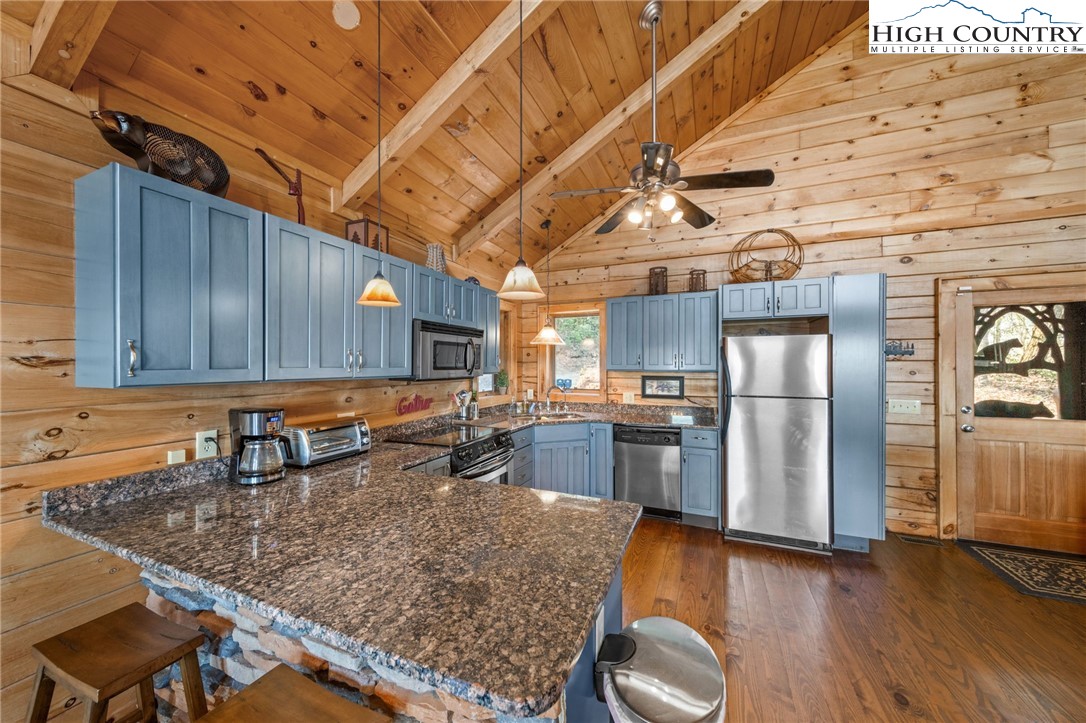 196 Eagle Nest Road Purlear, NC 28665 - Photo 17 of 36 a kitchen with stainless steel appliances granite countertop a sink window and wooden cabinets