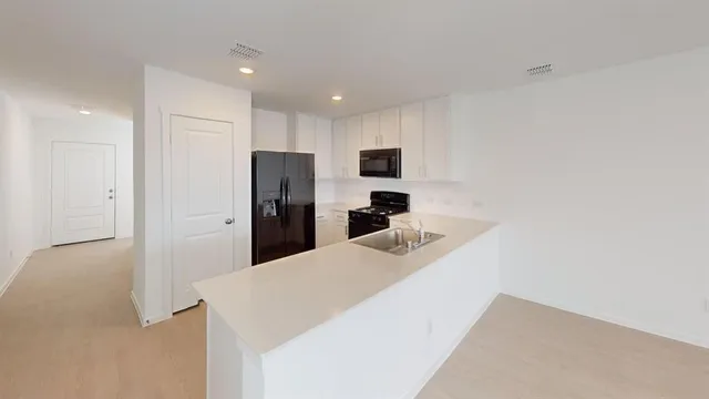 a kitchen with stainless steel appliances kitchen island a refrigerator sink and cabinets