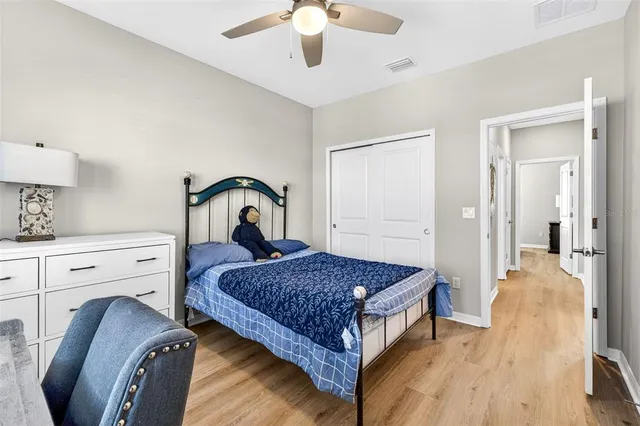 a bedroom with a bed and a lamp on dresser