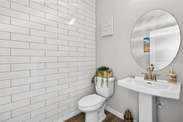 a bathroom with a sink toilet and a mirror