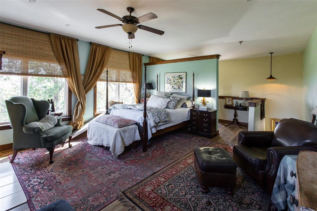 1775 Sunset Mountain Road Lipan, TX 76462 - Photo 17 of 34 a spacious bedroom with a bed a couch and large window