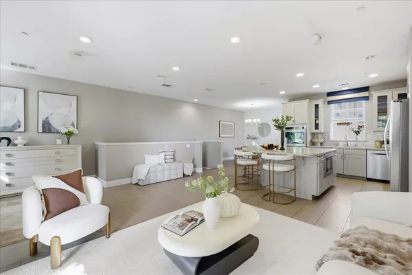 a living room with furniture and kitchen view