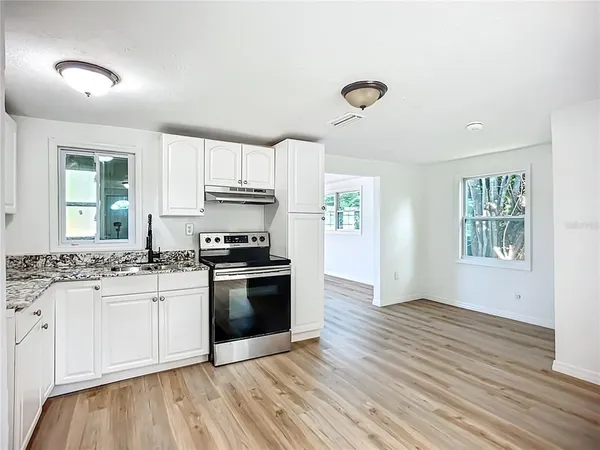 a kitchen with granite countertop a stove and a sink